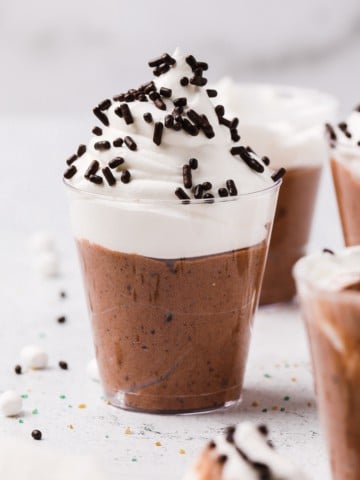 a hot chocolate pudding shot completed and topped with whipped cream