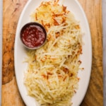 a platter of shredded hash browns and ketchup