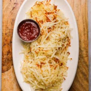 a platter of shredded hash browns and ketchup