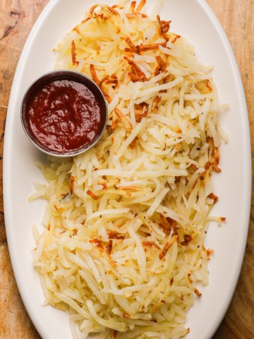 a platter of shredded hash browns and ketchup