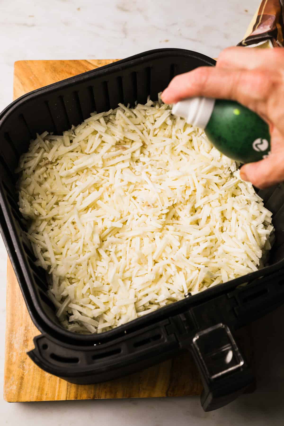 spraying hash browns with cooking spray