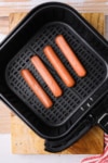 uncooked hot dogs in air fryer basket