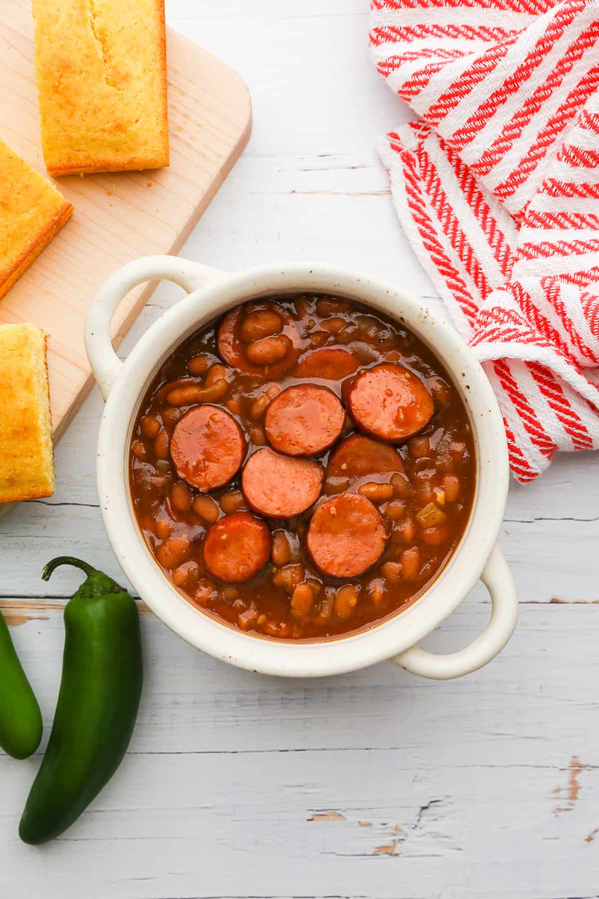 a bowl of baked beans with sliced sausage mixed in