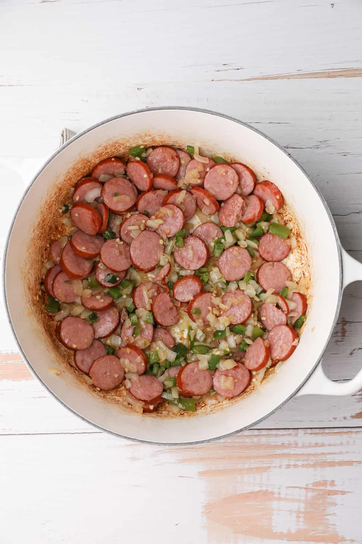 sliced sausage cooking in a dutch oven