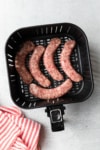 uncooked brats in the air fryer basket