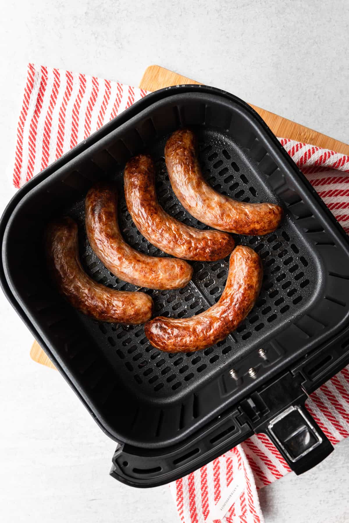 cooked brats in an sir fryer basket