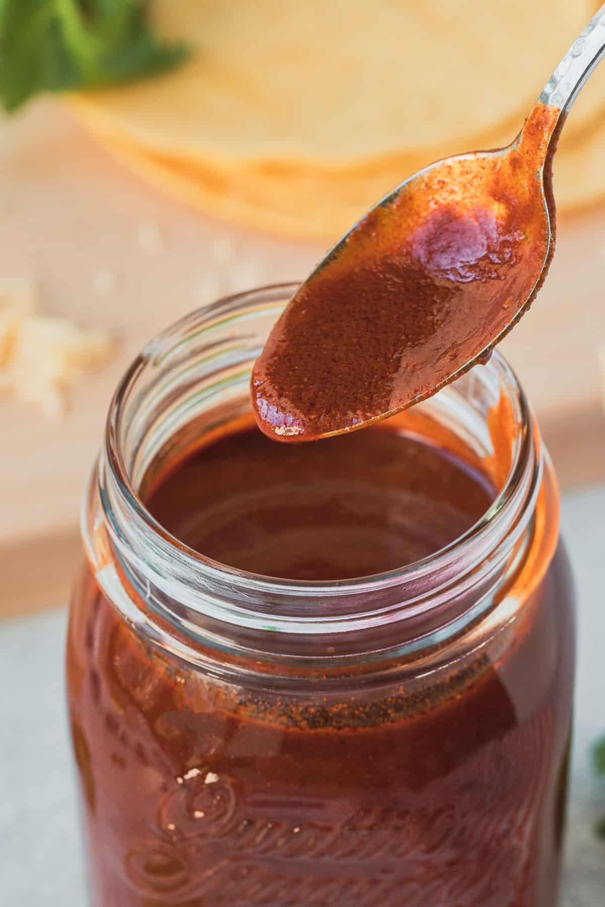 a spoon dipping into enchilada sauce