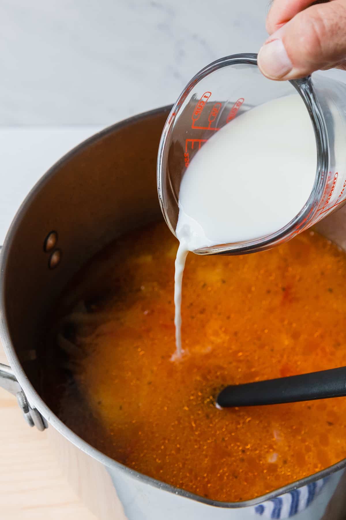 adding milk to make the soup