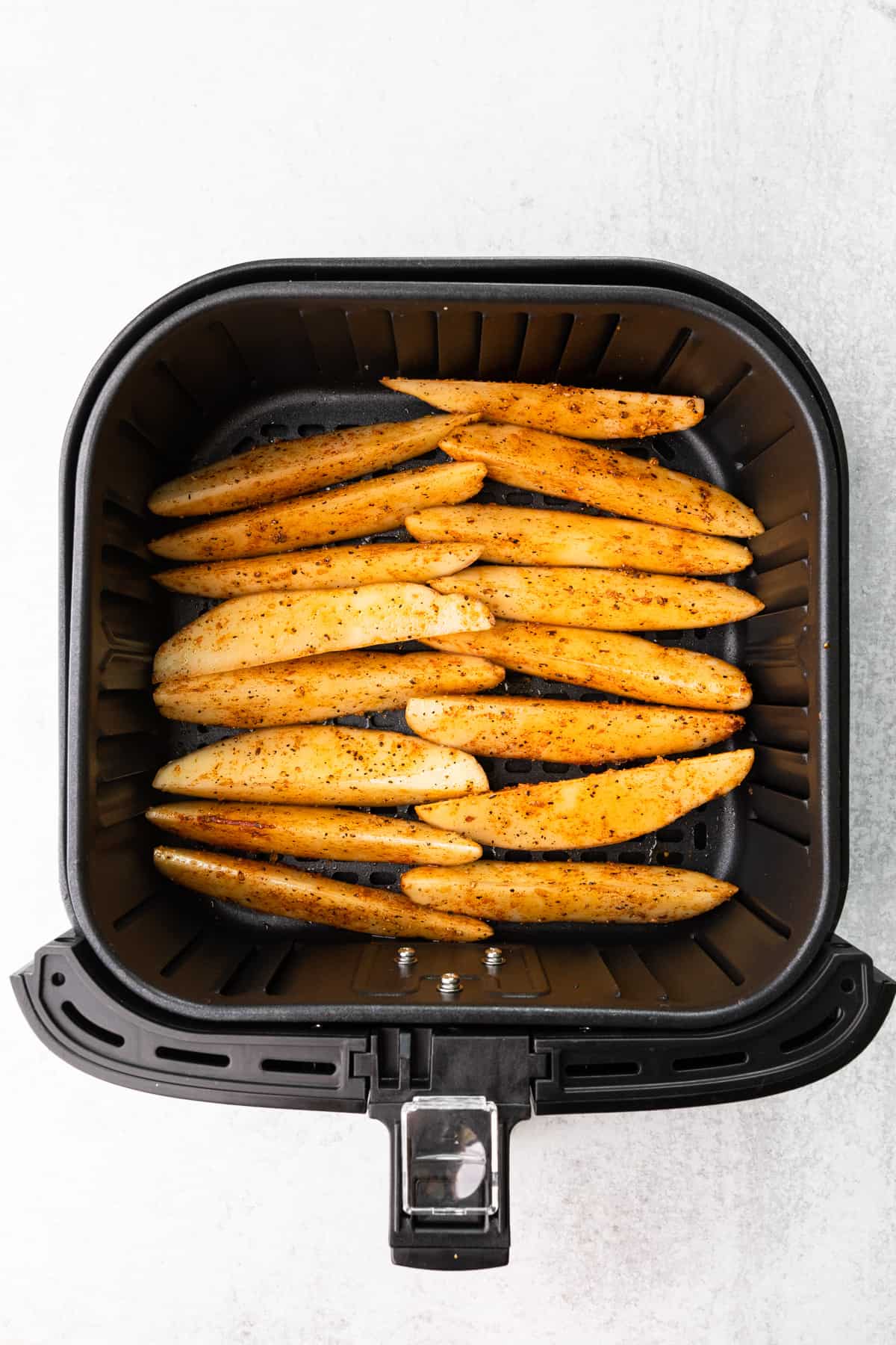 steak fries in an air fryer basket before cooking