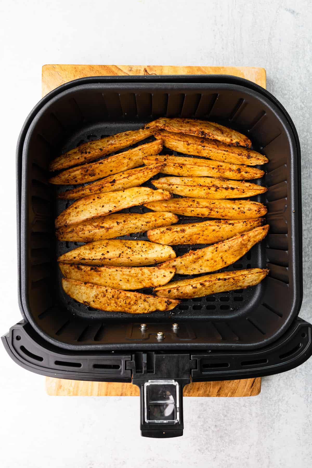 cooked steak fries in an air fryer basket