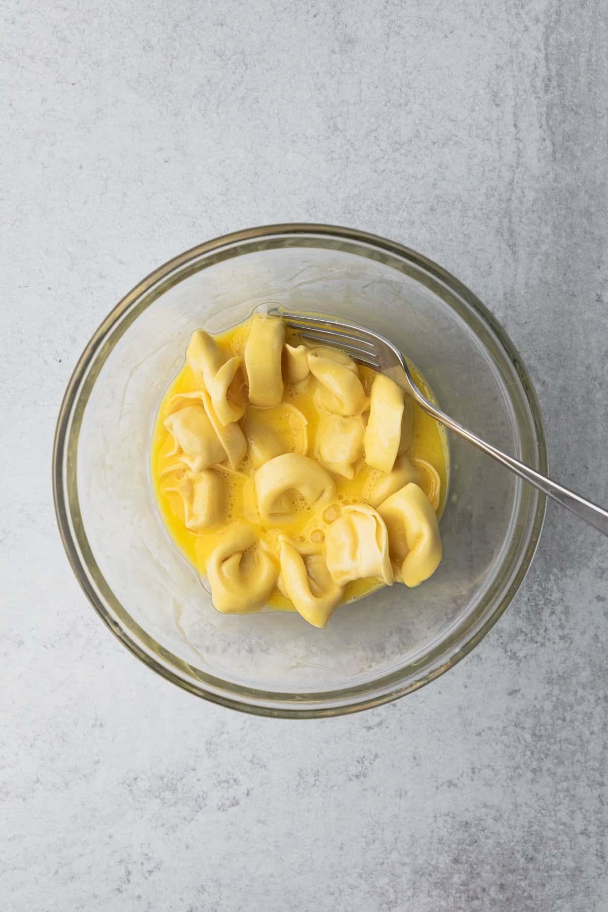 Tortellini coated in beaten eggs.