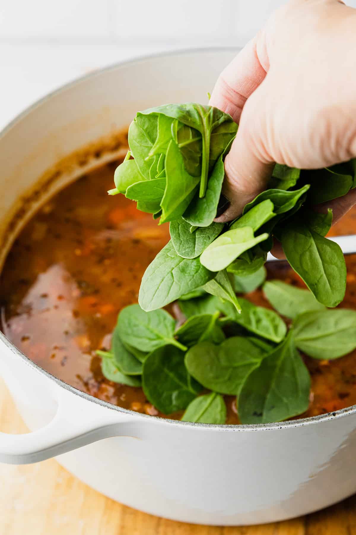 adding fresh spinach to make panera 10 vegetable soup recipe