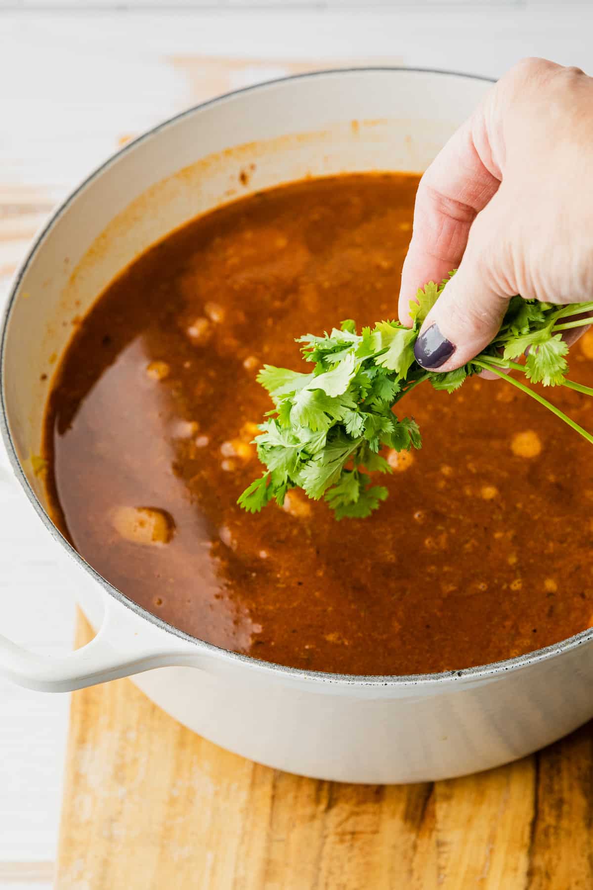 adding fresh cilantro to make vegetable soup