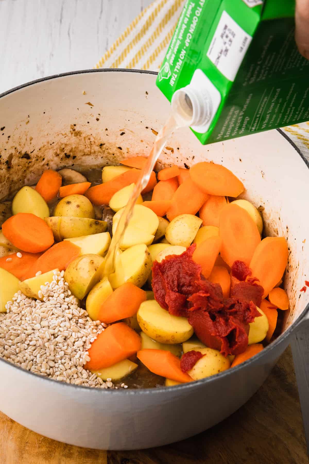 pouring vegetable broth into soup pot