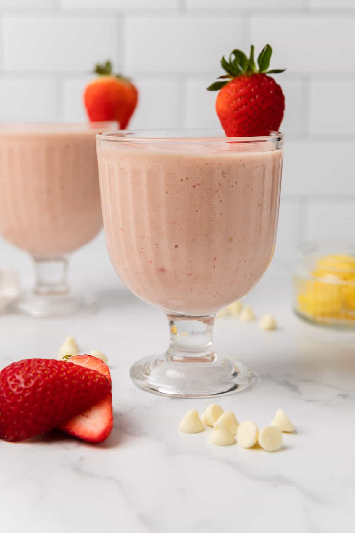 the completed smoothie recipe in a glass with a strawberry garnish on the rim