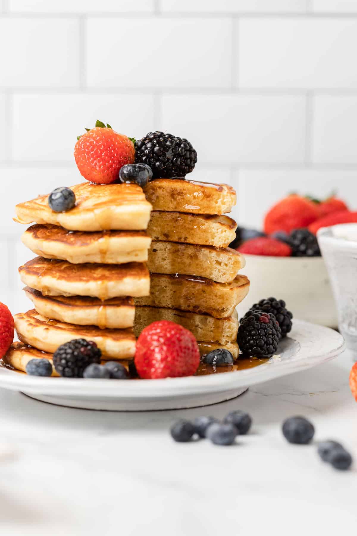 a stack of pancakes cut through with fruit and syrup