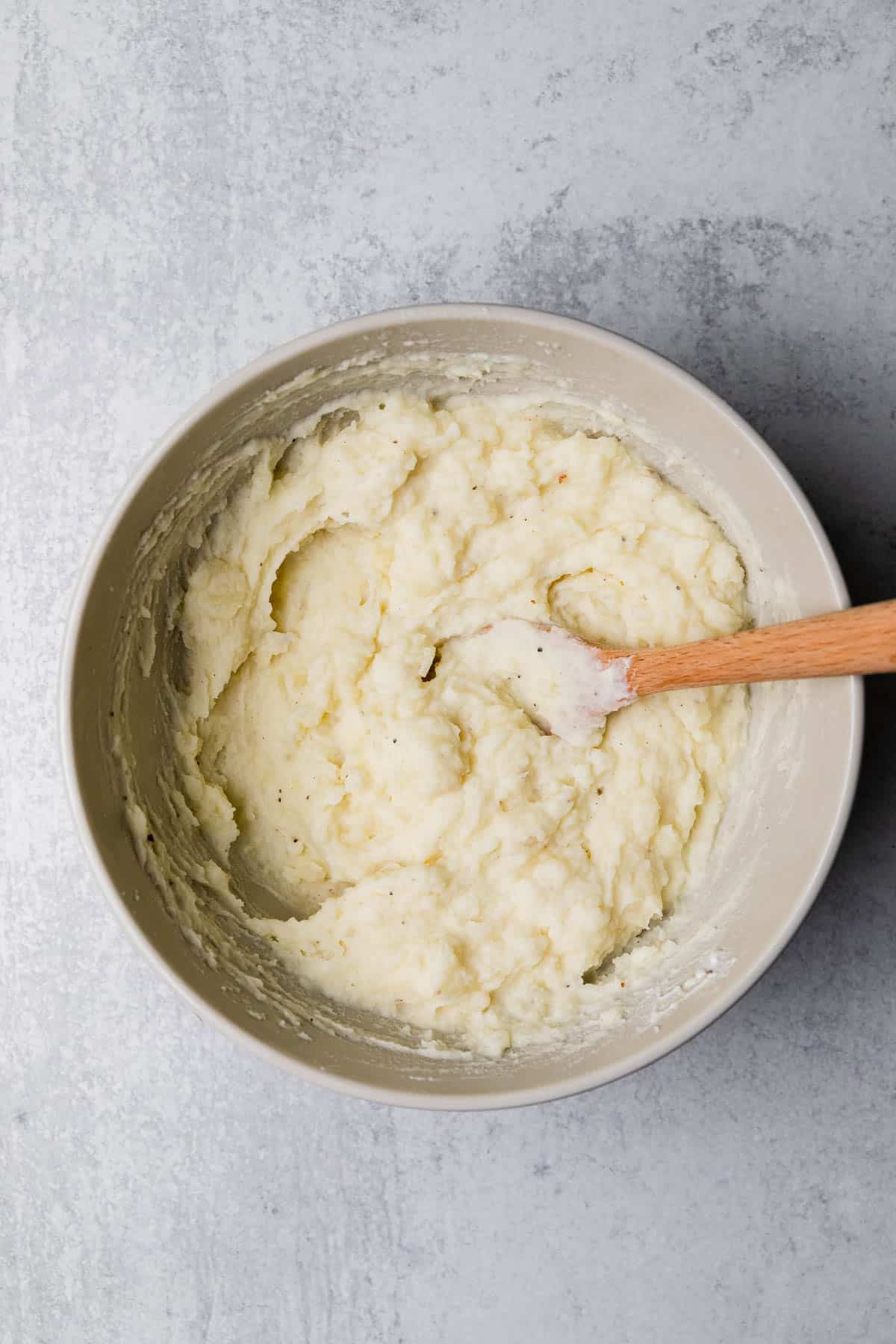 whipping potatoes with a wooden spoon