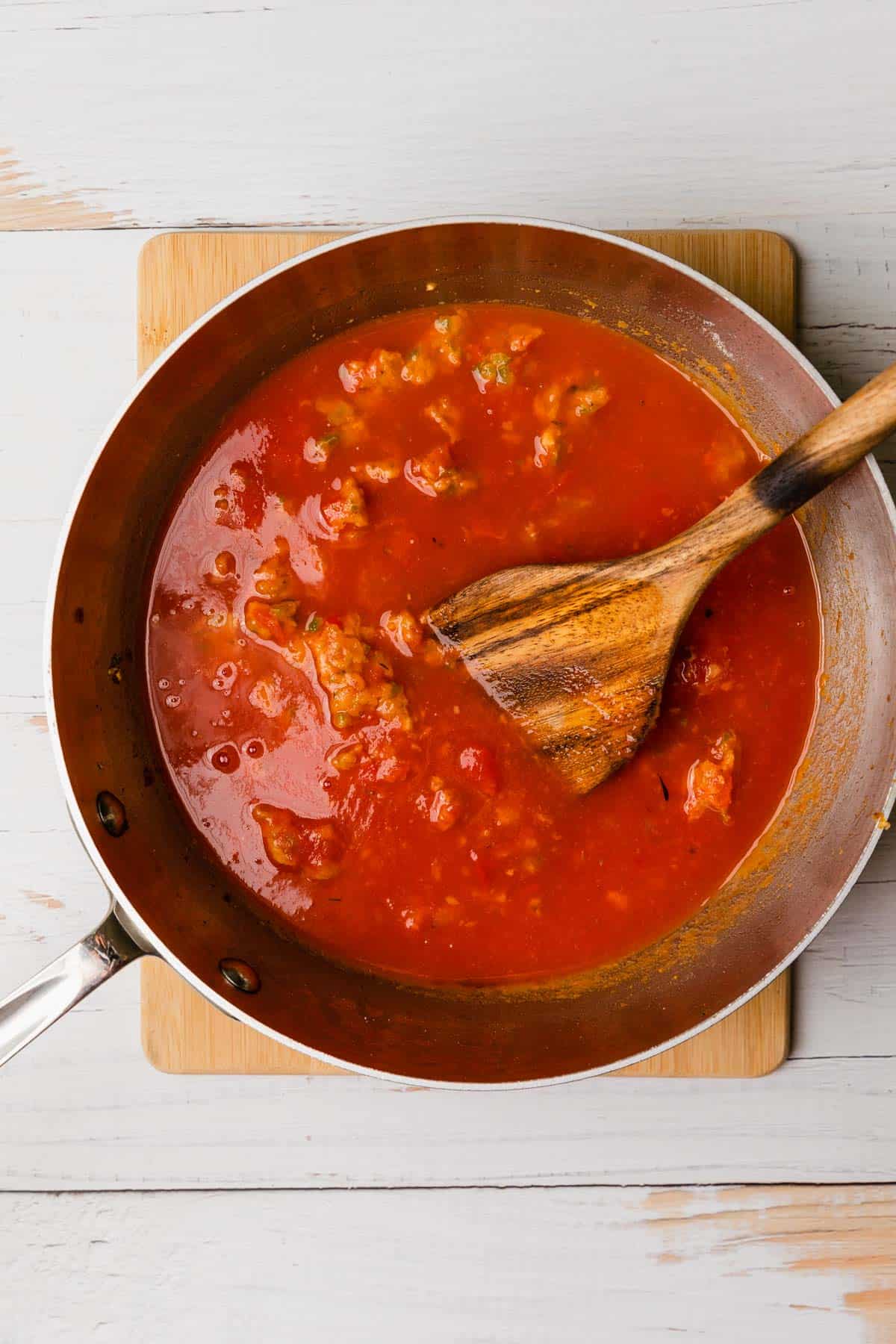 adding canned tomato sauce to make the complete sauce