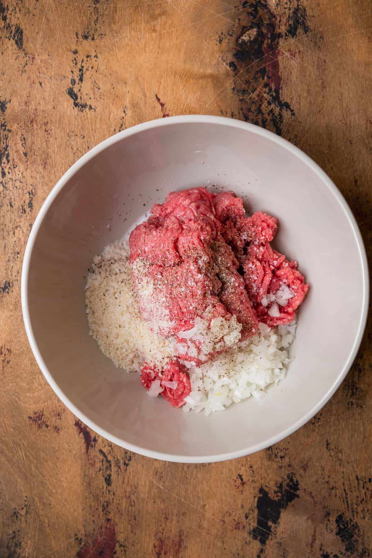 mixing raw ground beef to make hamburger patties