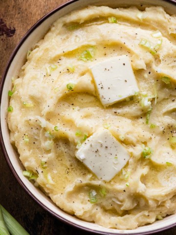 a bowl of mashed potatoes with melting butter on top