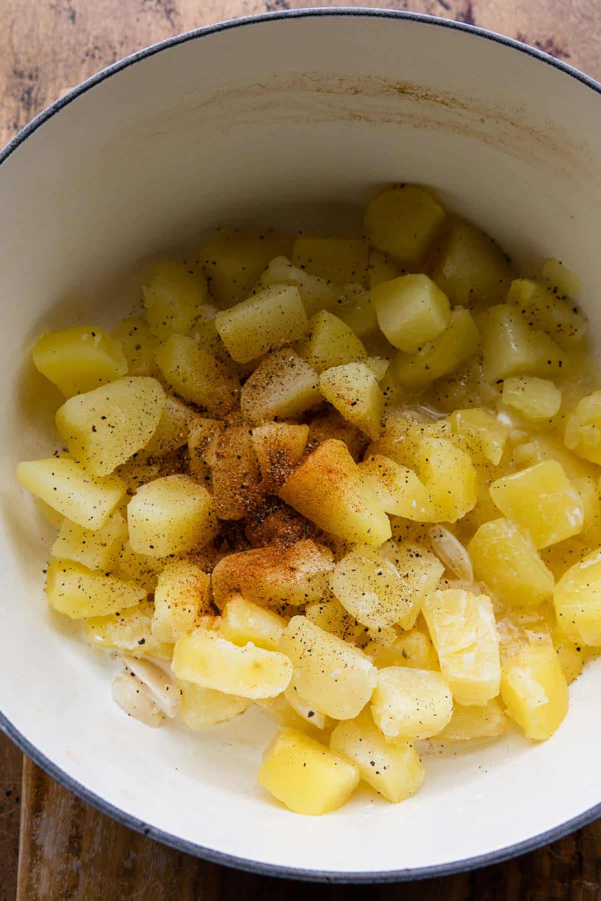 adding the cajun seasoning to cooked potatoes to make the reicpe