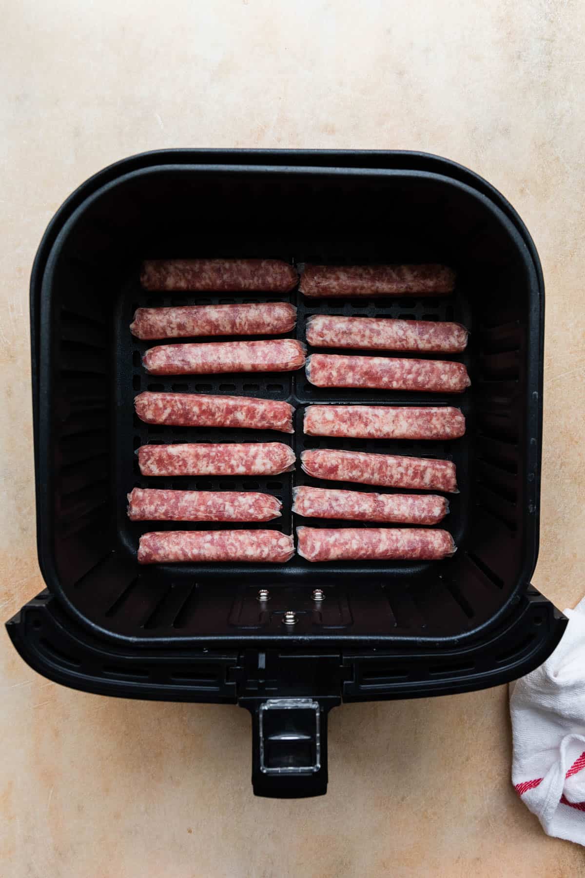 uncooked sausage links in air fryer basket