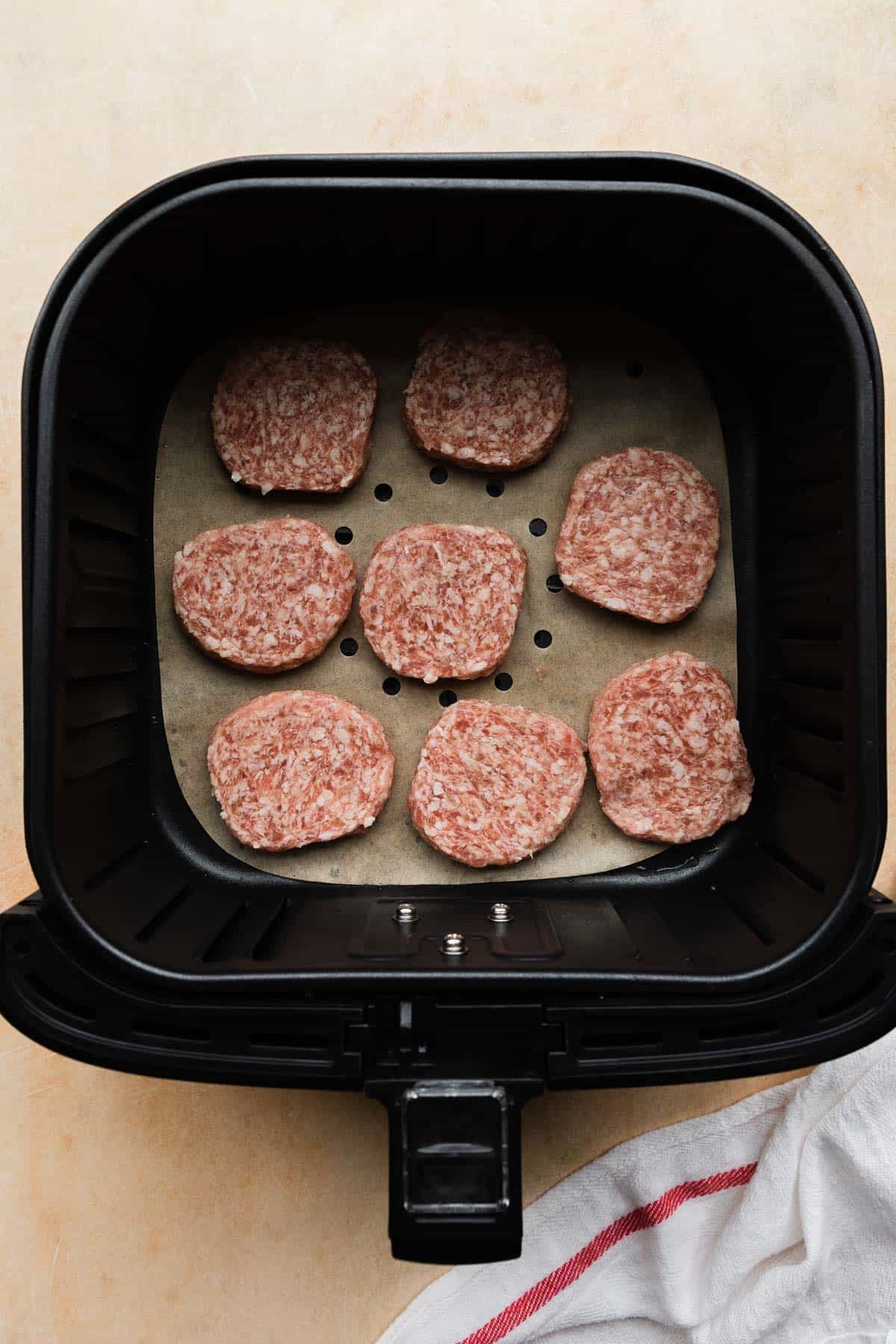 raw sausage patties in the air fryer basket