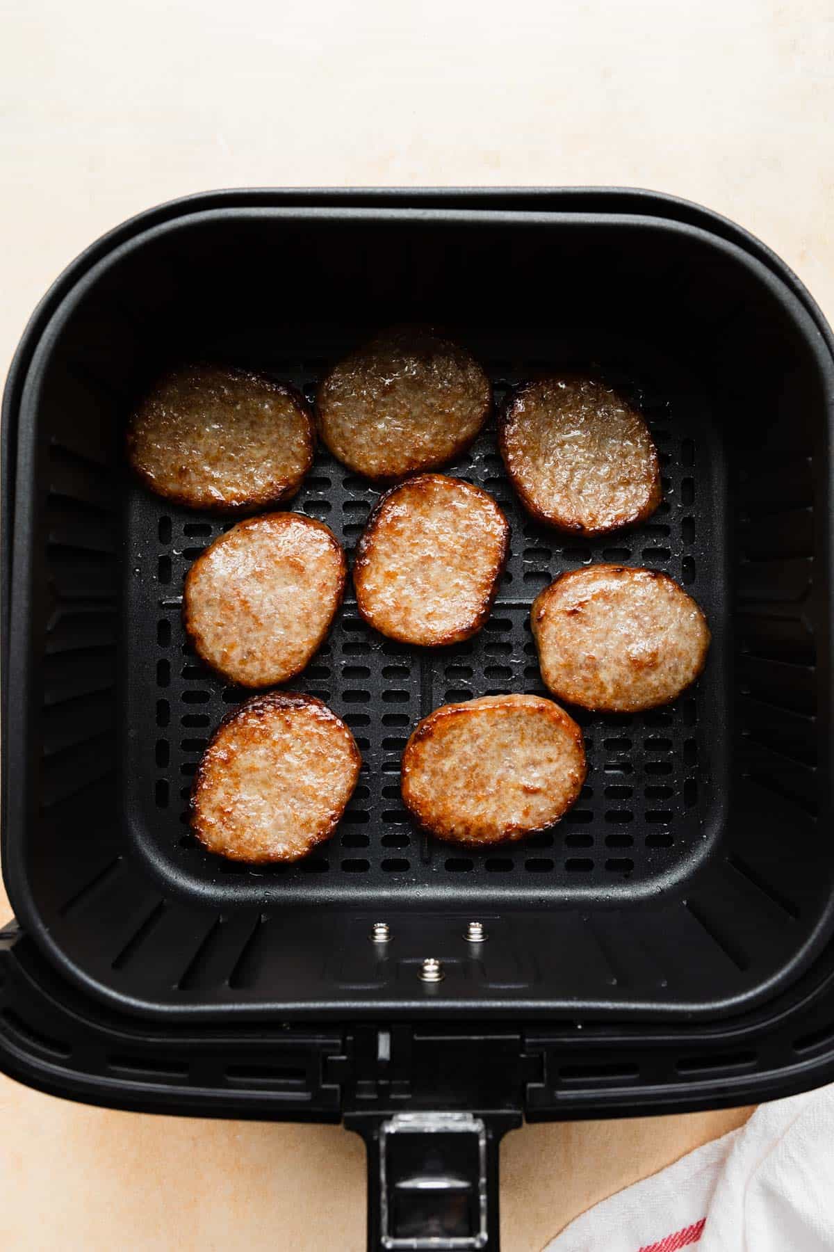 cooked sausage patties in the air fryer basket