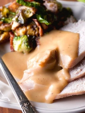 a plate of gravy and turkey
