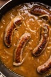 sausages simmering in stout gravy with onions