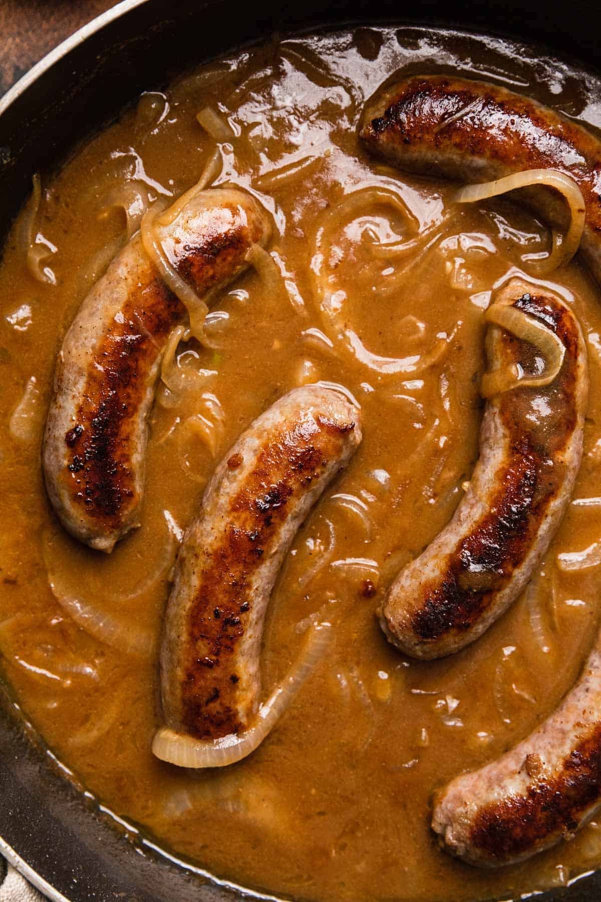 sausages simmering in stout gravy with onions