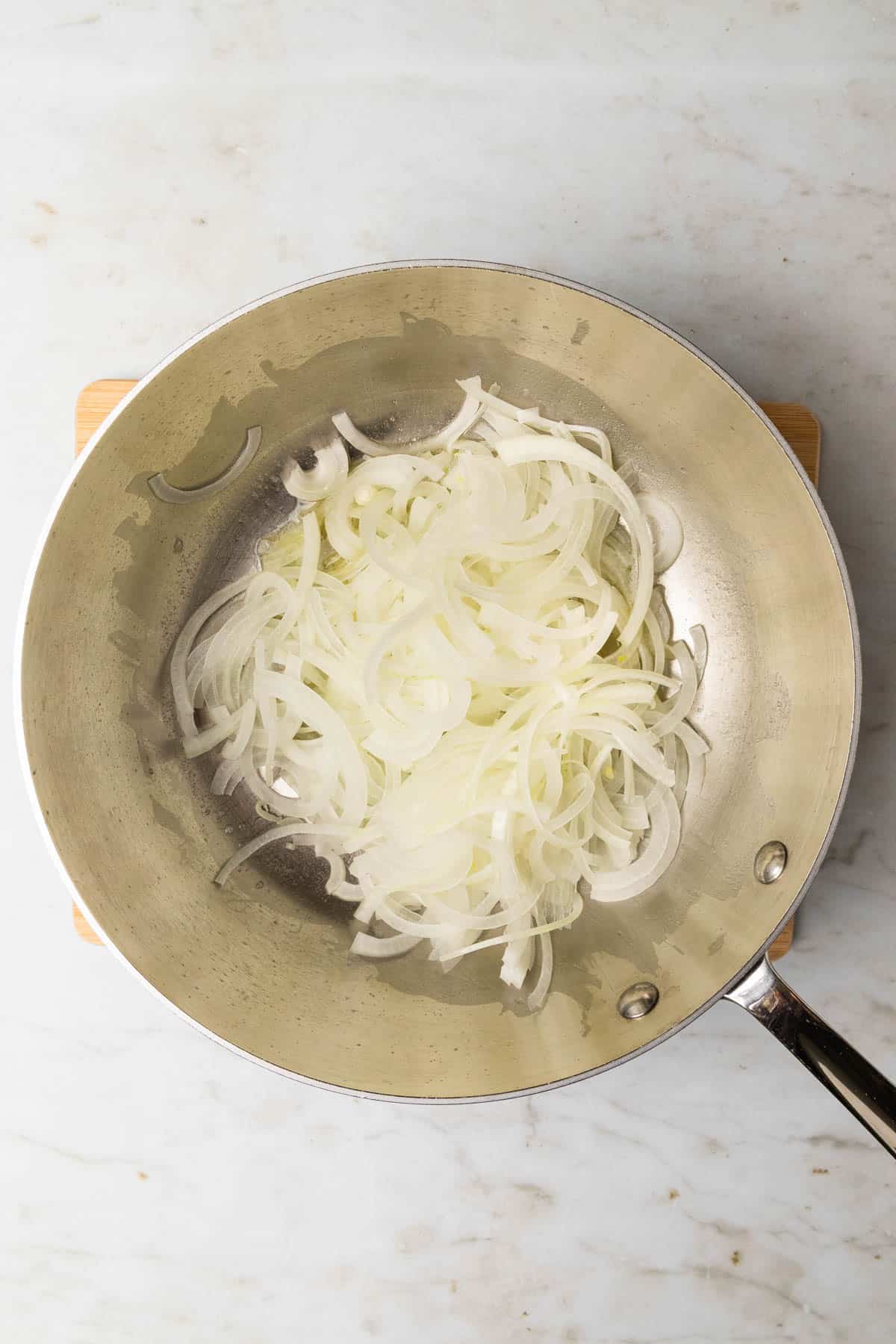 adding sliced onions to pan