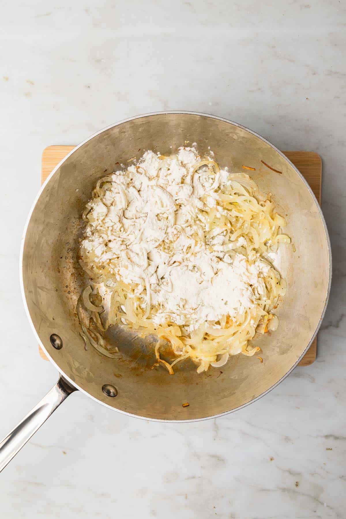 adding flour to cooked onions 