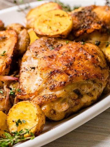The completed recipe of chicken thigh and potatoes made in the air fryer.