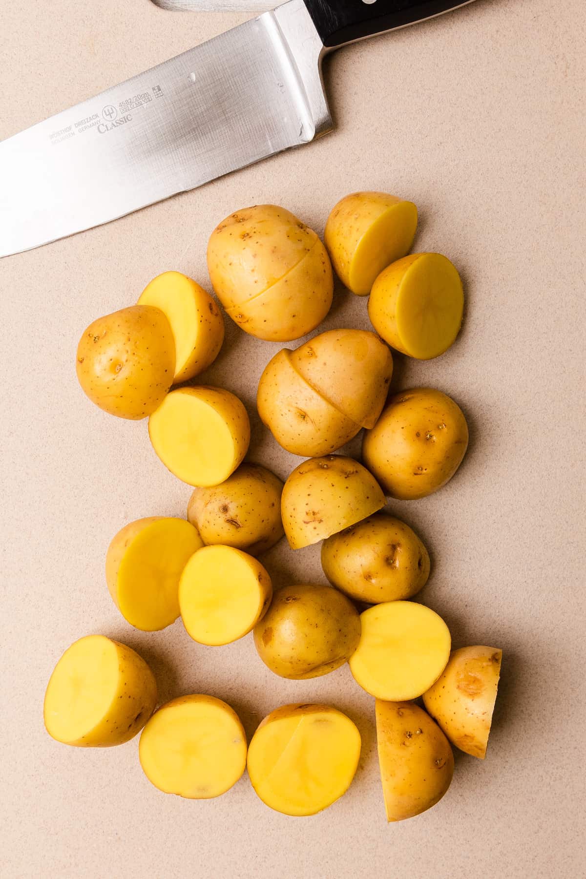 Making the recipe by cutting potatoes in half.