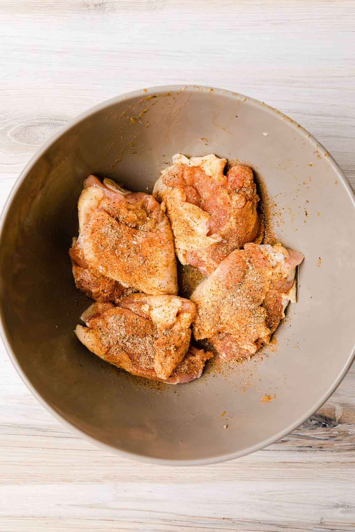 Making the recipe by seasoning chicken.