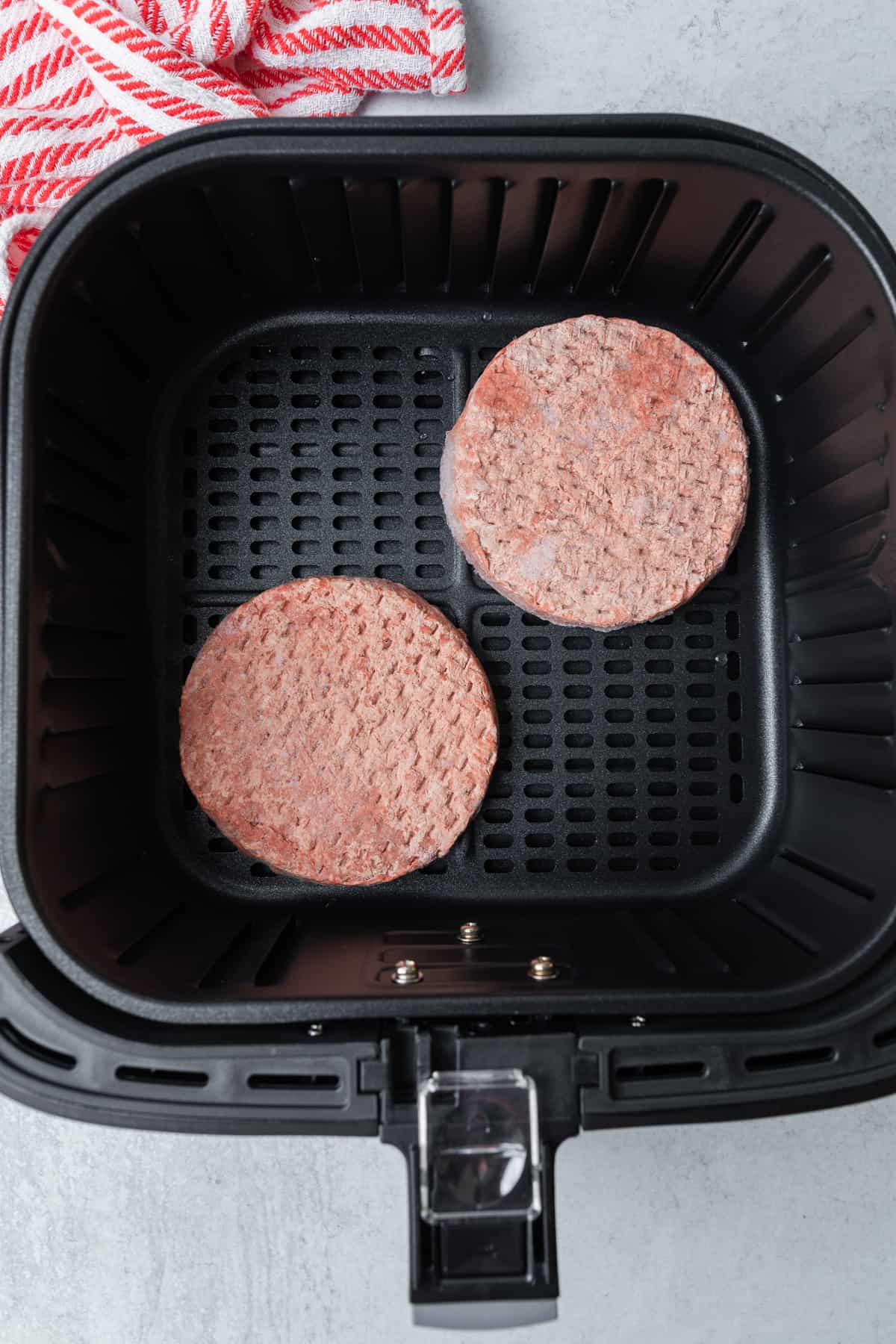 2 burger patties being cooked in a cosori air fryer