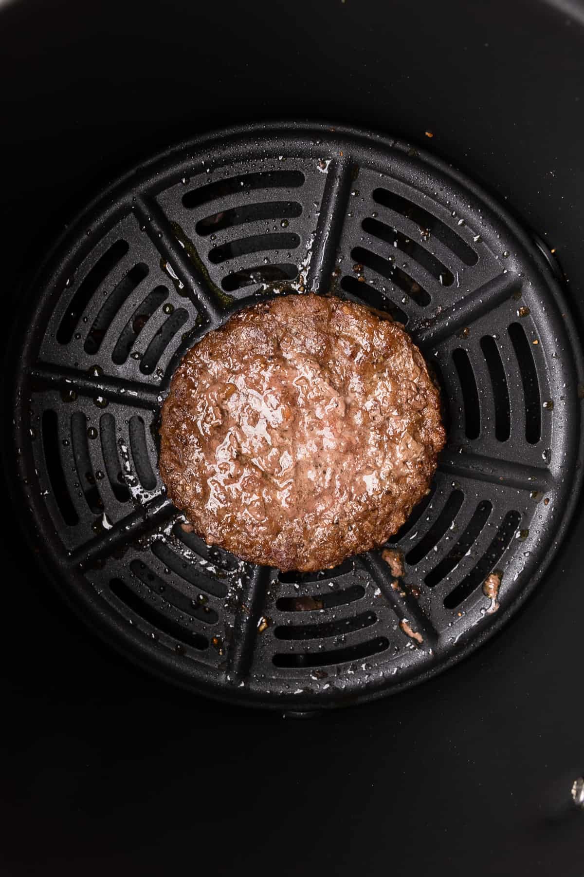 the cooked burger patty in the air fryer
