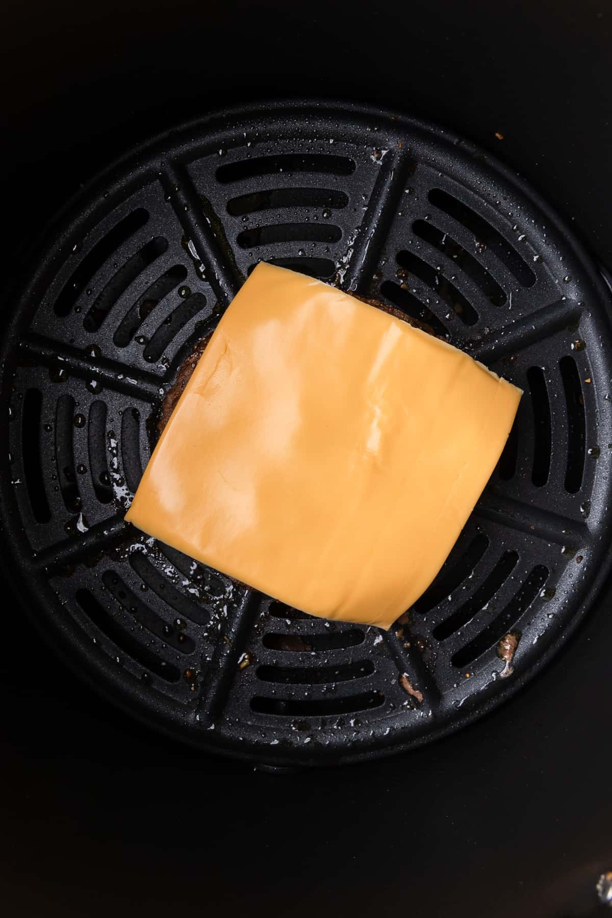 melting cheese on the burger patty to make a cheeseburger