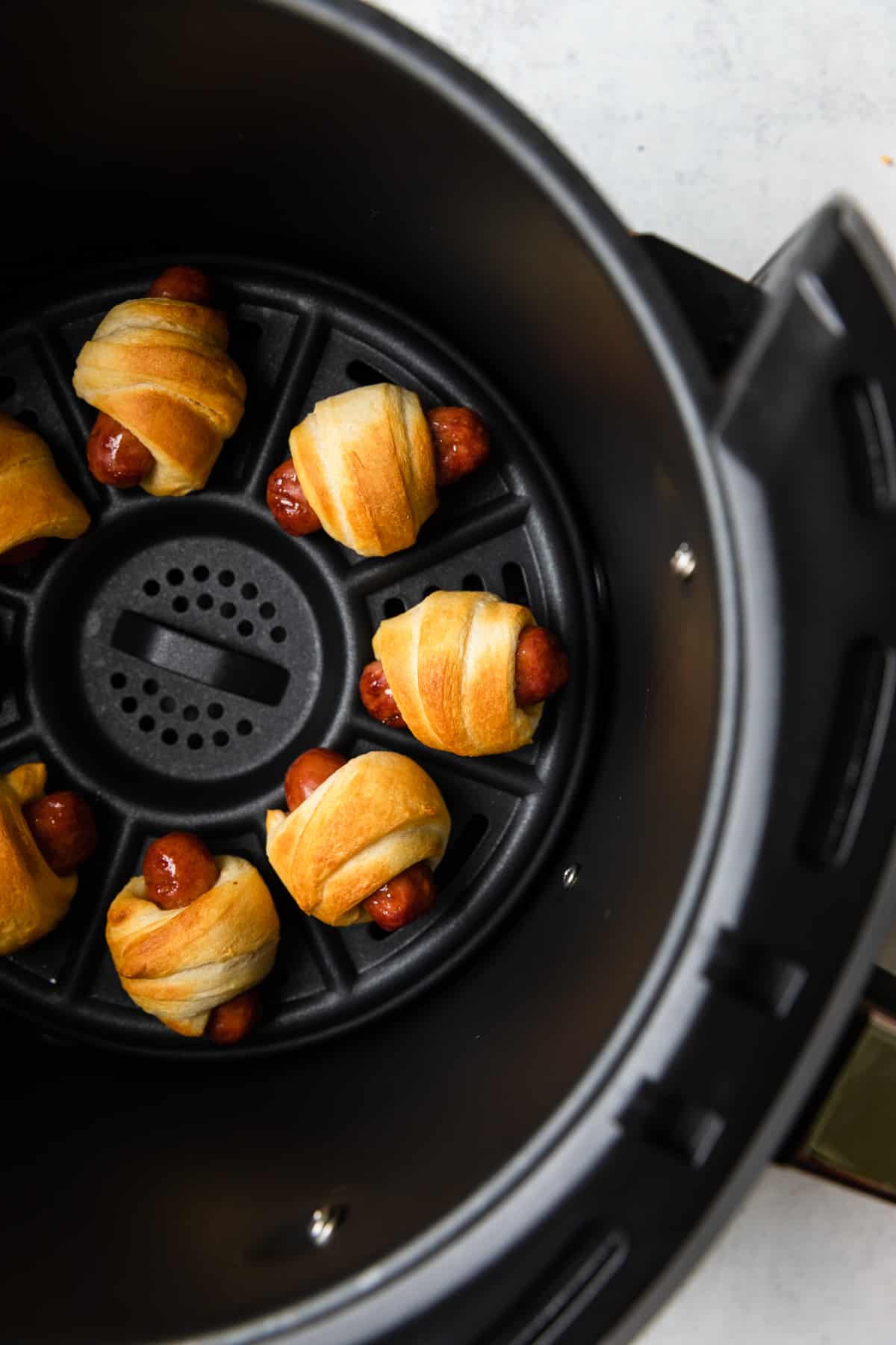 Process of cooked pigs in a blanket in the basket.