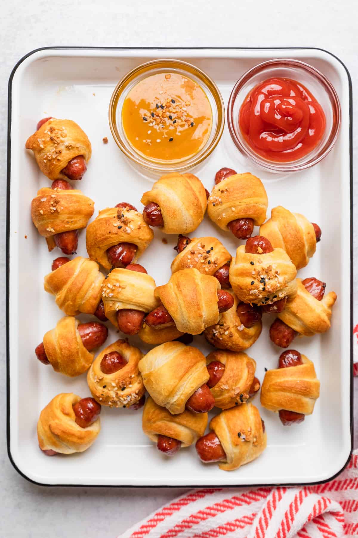 The completed pig in a blanket recipe on a white platter.