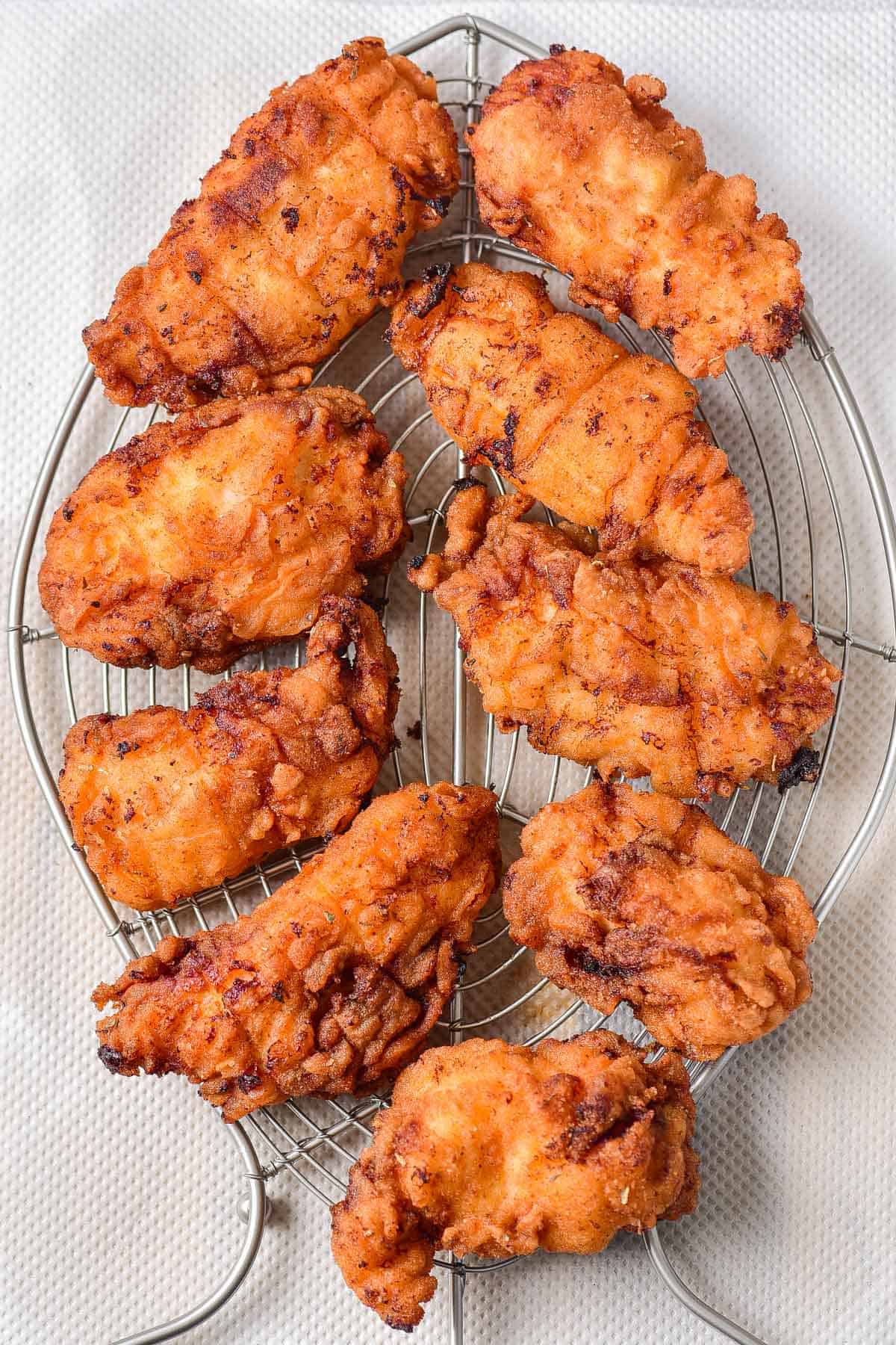 Draining fried chicken on a rack.