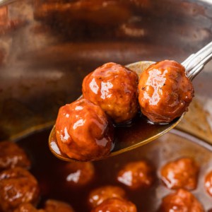 The completed instant pot grape jelly meatballs on a spoon.