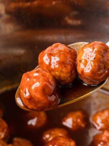 The completed instant pot grape jelly meatballs on a spoon.