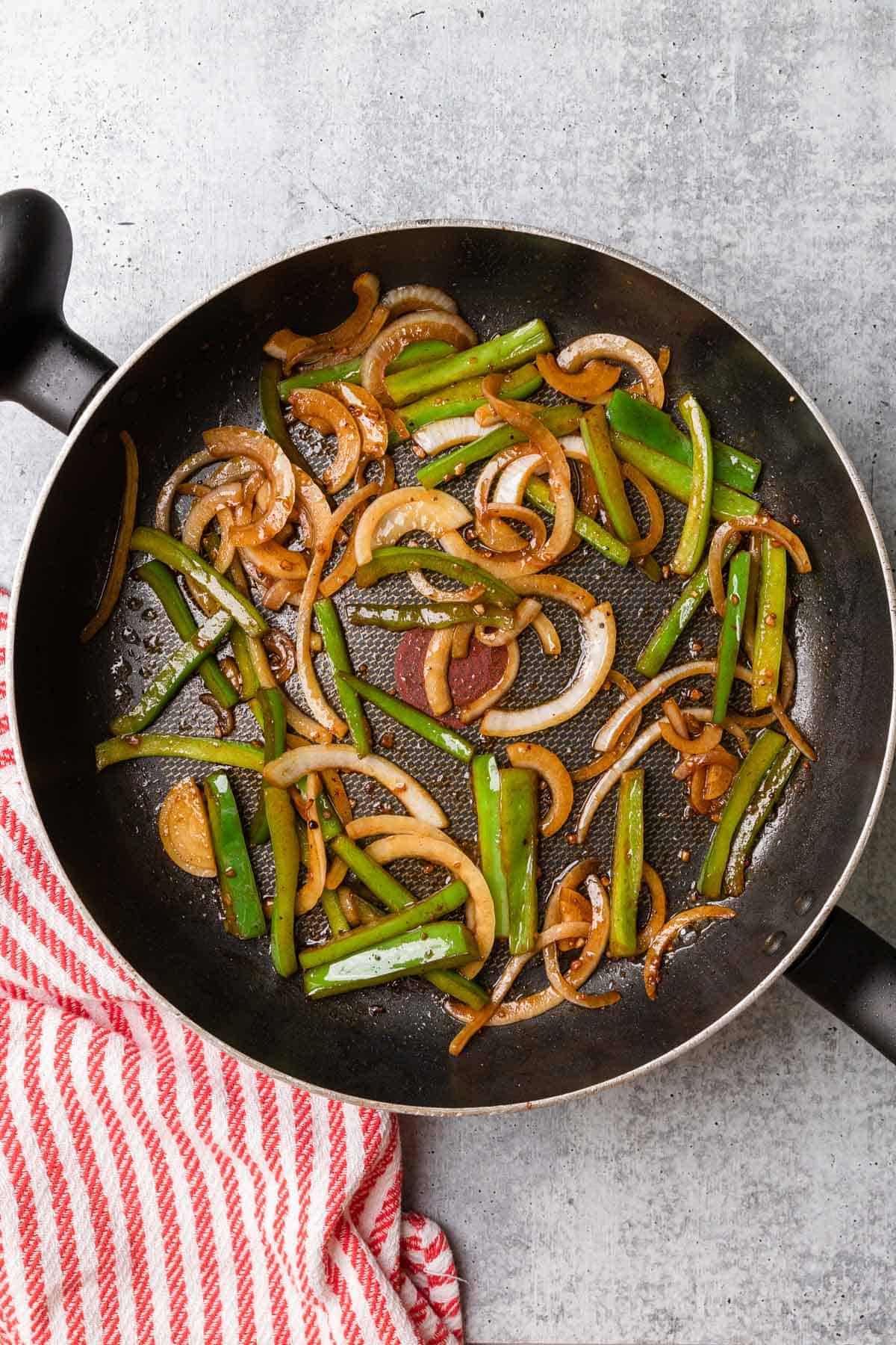 cooking peppers and onions to make the recipe