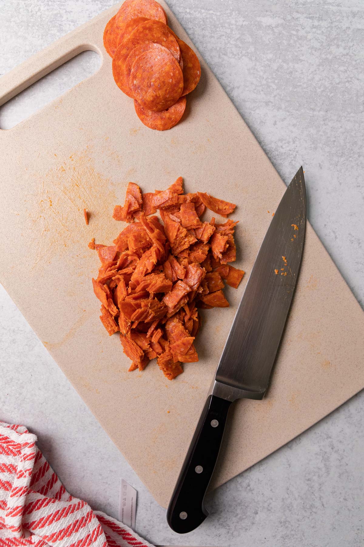 cutting the pepperoni to make the recipe