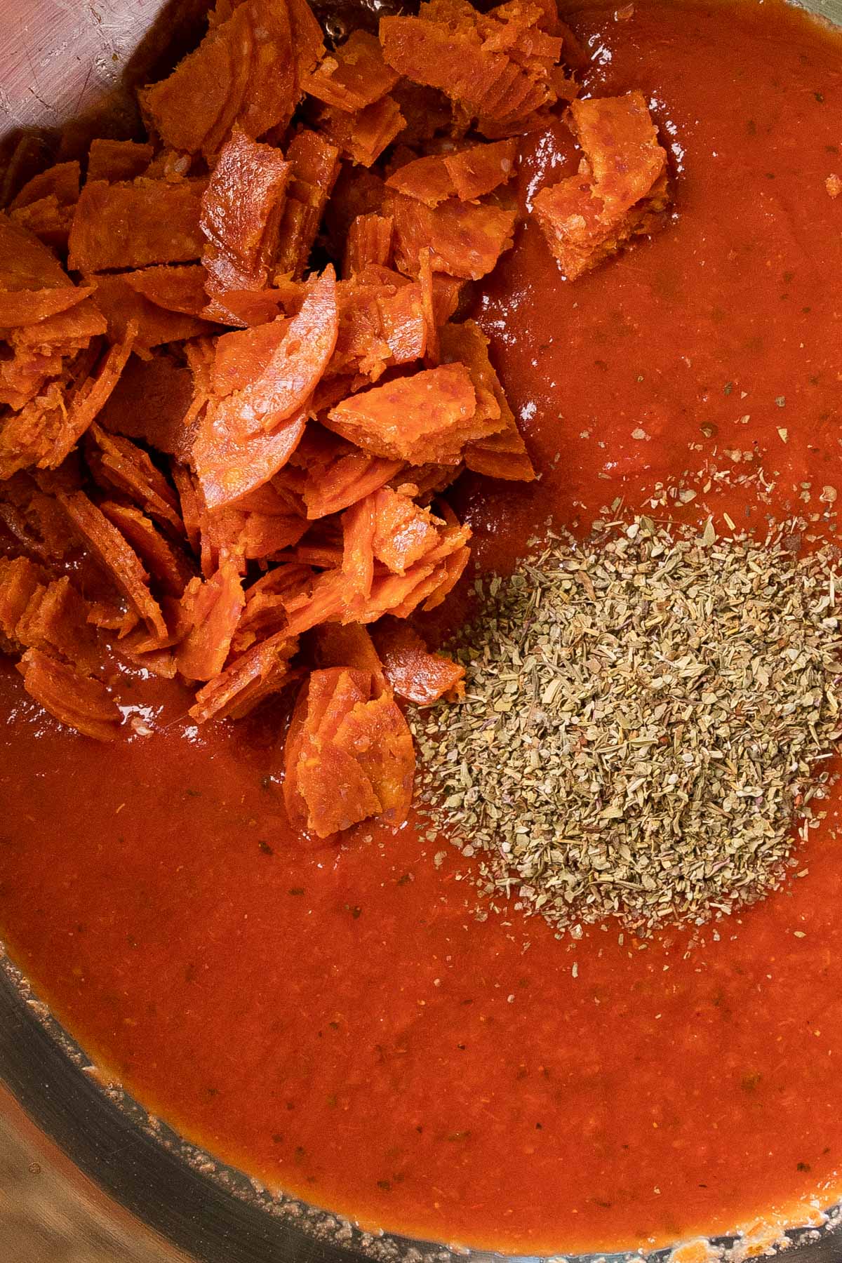 mixing the sauce and pepperoni to make the recipe
