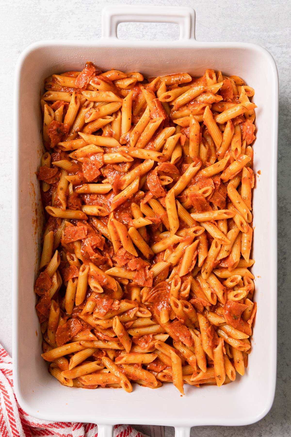 pouring the pasta mixture into the casserole dish