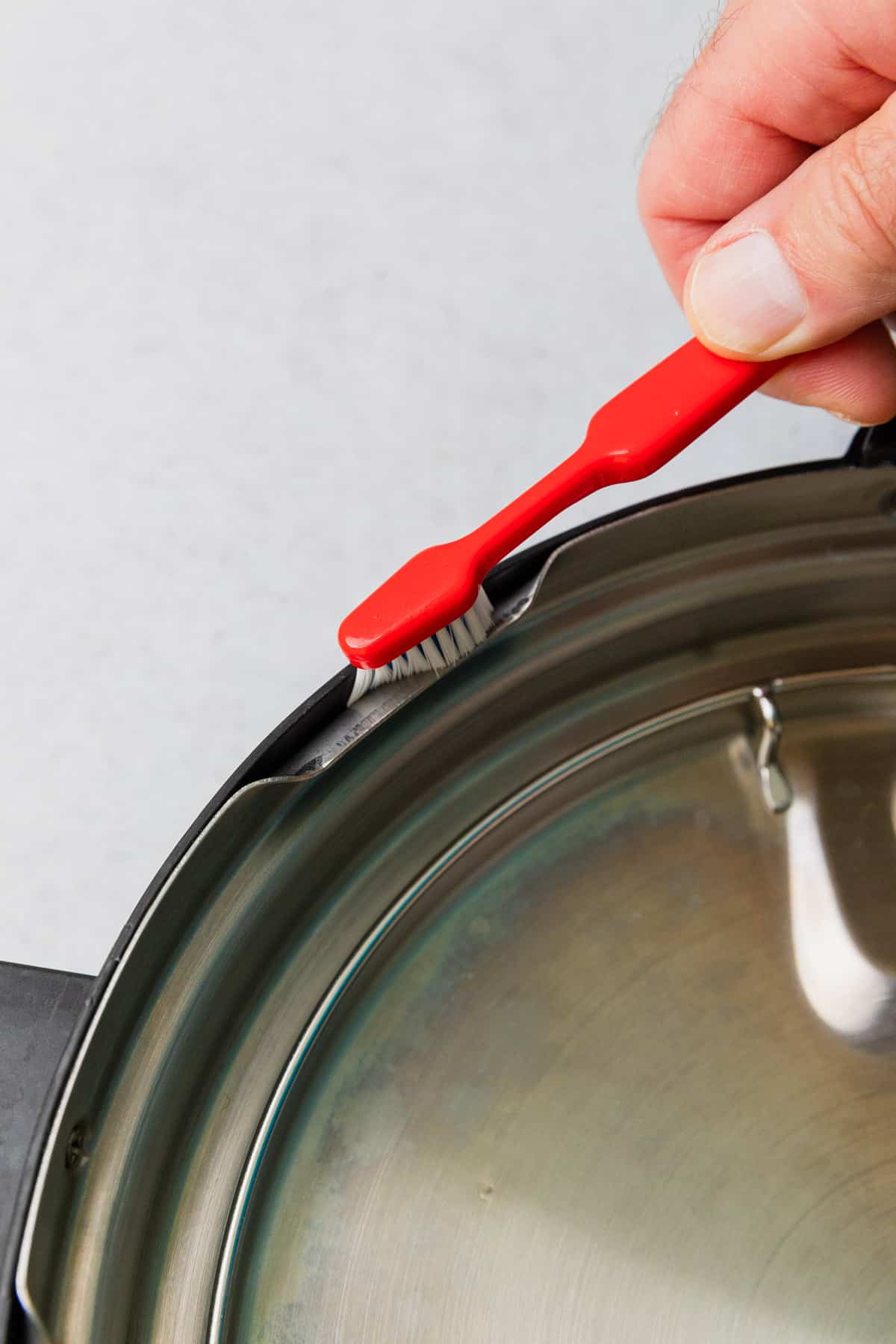 cleaning the instant pot with a toothbrush