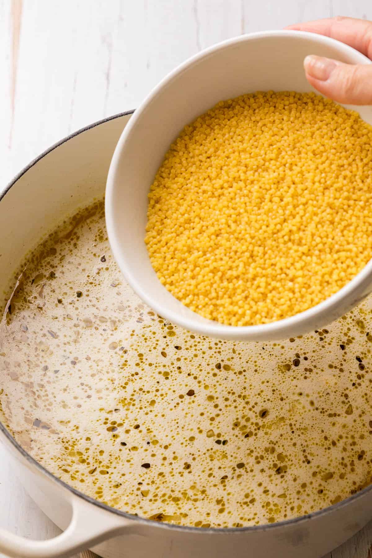 Adding pastina to broth.